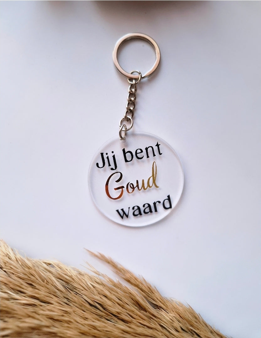Ronde acryl sleutelhanger met zwart en goud opschrift "jij bent goud waard"