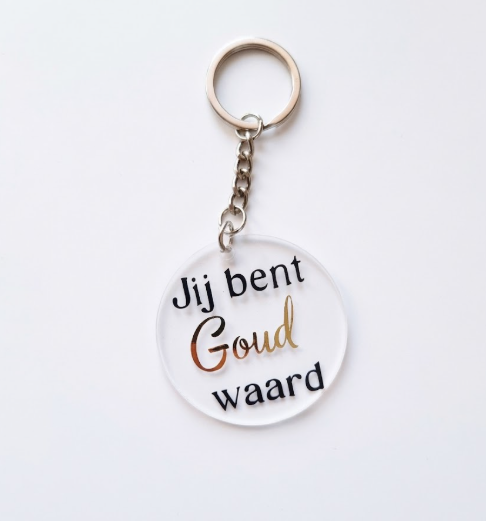 Ronde transparante acryl sleutelhanger met de tekst 'Jij bent Goud waard' in zwart en goudfolie letters.