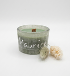 Groene-stone-candle met de naam Maurice bedrukt in wit vinyl en gepresenteerd met  droogbloemen