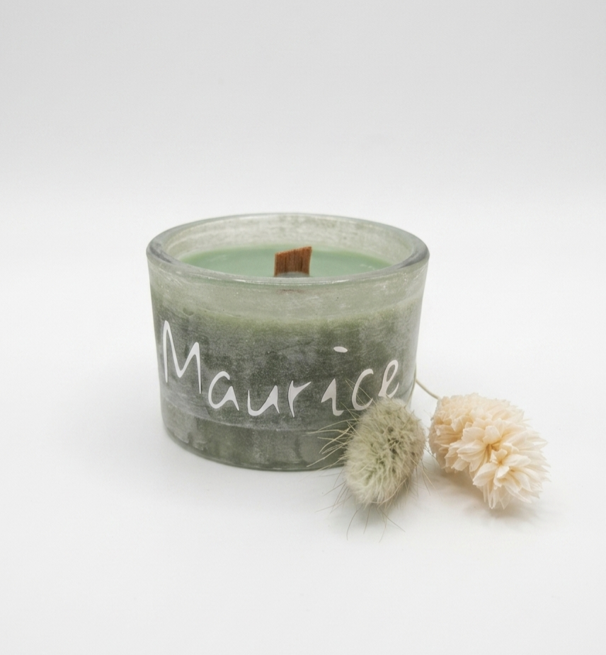 Groene-stone-candle met de naam Maurice bedrukt in wit vinyl en gepresenteerd met  droogbloemen