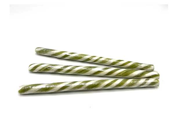 Assortiment van 20 gestreepte artisanale zuurstokken in verschillende kleuren zoals groen, geel, oranje en paars.