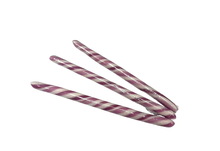 Assortiment van 20 gestreepte artisanale zuurstokken in verschillende kleuren zoals groen, geel, oranje en paars.