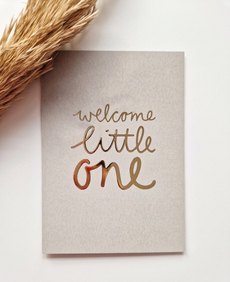 Luxe groene wenskaart met gouden tekst 'welcome little one' naast een droogbloem decoratie.